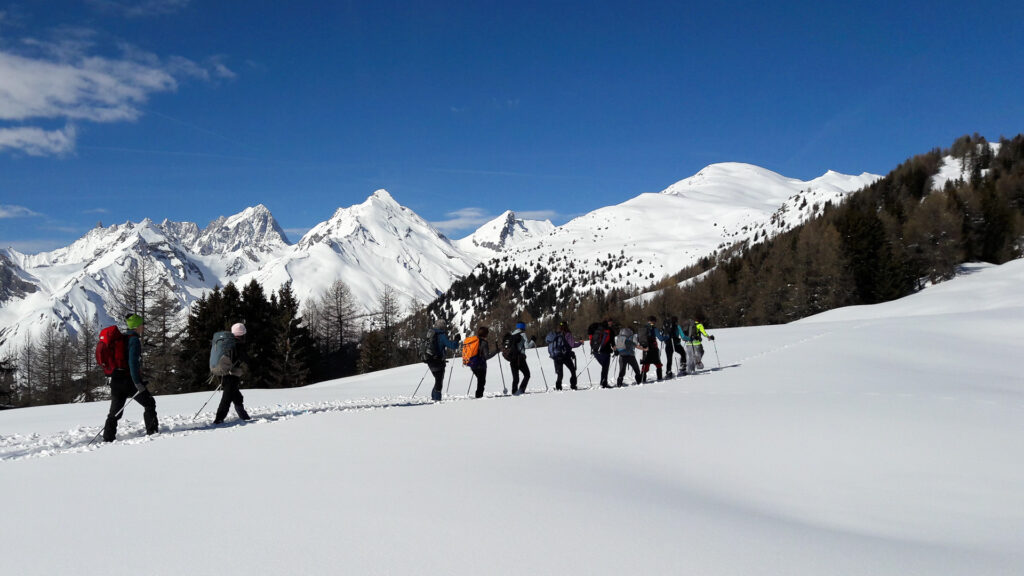 groupe en raquettes dans le Val d'Aoste devant la chaîne du Mont Blanc