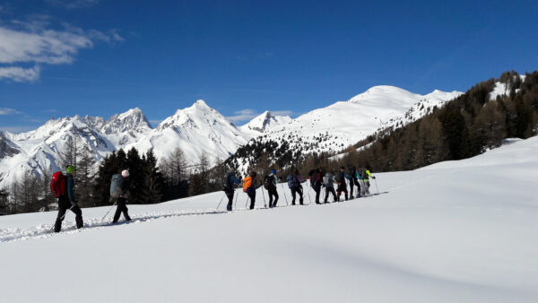 groupe en raquettes dans le Val d'Aoste devant la chaîne du Mont Blanc