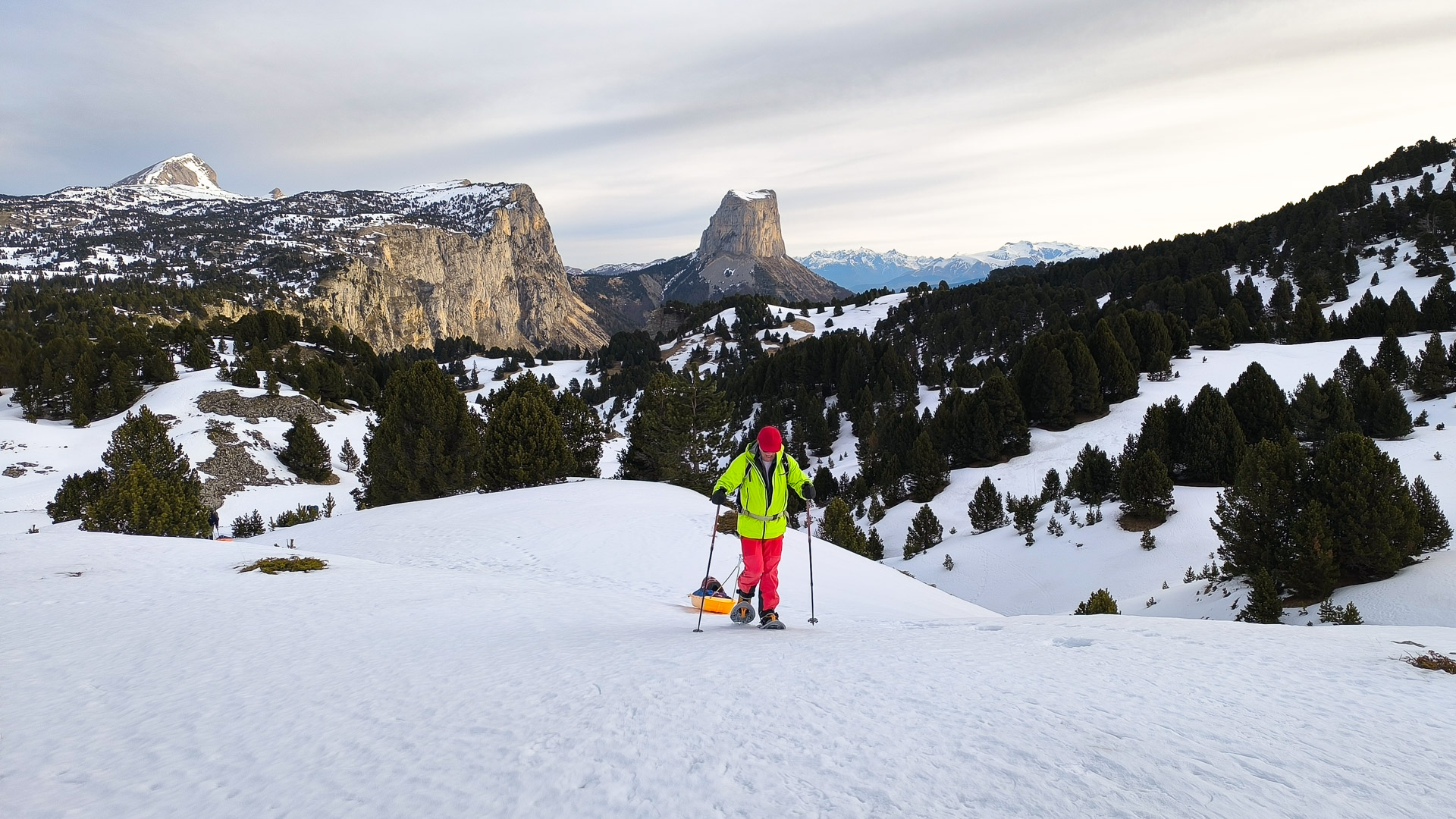 randonneur en raquettes-pulka devant le Mont Aiguille